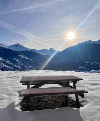 a picnic table sitting on top of a snow covered mountain at Thyon 4pièces, magnifique vue in Hérémence