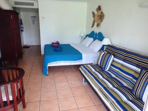 a hotel room with a bed and a couch at Village vacances Sainte LUCE studio ANTIGUA 4 in Sainte-Luce