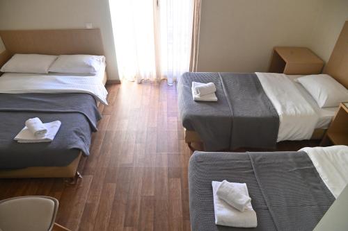 a hotel room with two beds with towels on them at Kentrikon in Chalkida