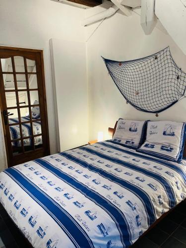 - une chambre avec un lit avec un filet suspendu au mur dans l'établissement Maison du pêcheur Normand, à Trouville-sur-Mer