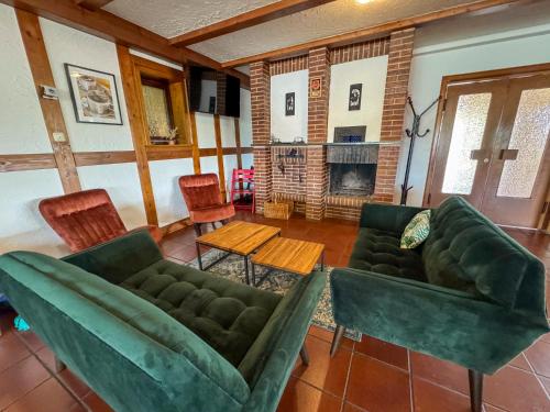 a living room with green couches and a fireplace at Berghotel Waidmannsheil in Battenberg