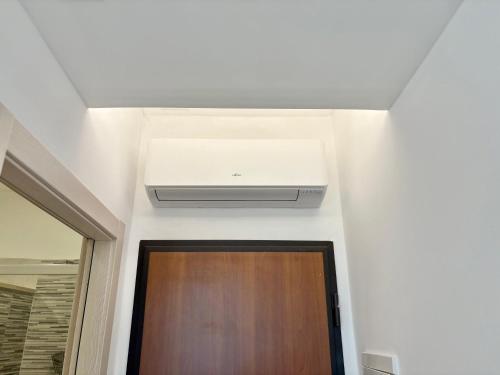 a ceiling fan in a room with a door at Romano's Luxury Stay b&b Bari in Bari