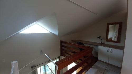 a room with a staircase with a window and a mirror at Pousada 4 Estações Campeche in Florianópolis