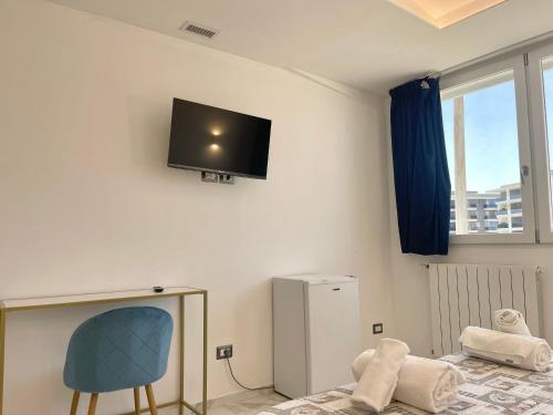 a room with a chair and a tv on the wall at Romano's Luxury Stay b&b Bari in Bari