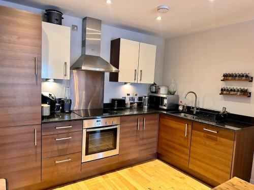 a kitchen with wooden cabinets and stainless steel appliances at 2 bed, 2 bath apartment in Roundhay in Moortown