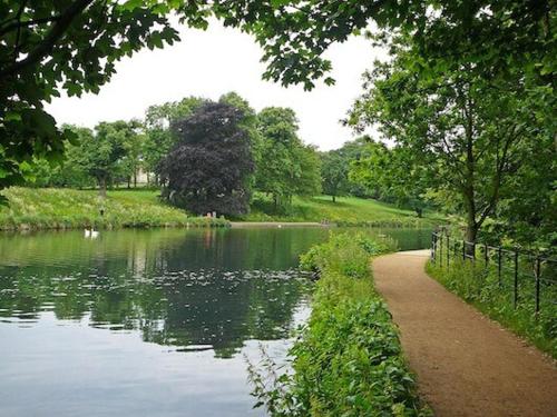 a path next to a lake with ducks in it at 2 bed, 2 bath apartment in Roundhay in Moortown