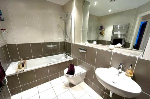 a bathroom with a toilet and a sink and a tub at 2 bed, 2 bath apartment in Roundhay in Moortown