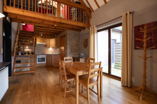 a kitchen and dining room with a wooden table and chairs at A little paradise Wallonie in Limelette