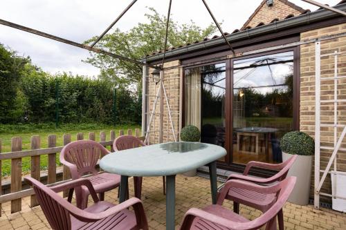 a table and chairs on a patio with a house at A little paradise Wallonie in Limelette