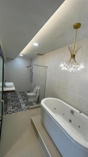 a white bathroom with a tub and a toilet at Eastern View Resort and Pool Villa in Ban Tao Than