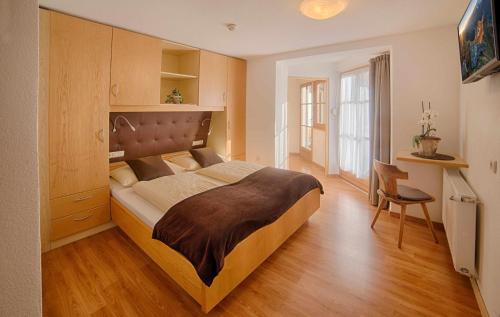 a bedroom with a large bed and a chair at Apartments & Wellness Löfflerblick in Cadipietra