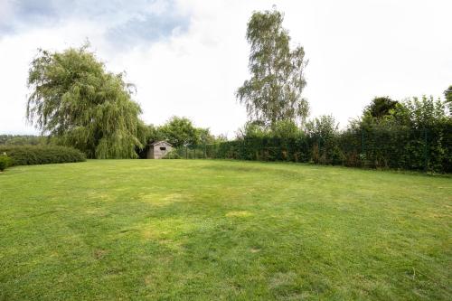 a large grass field with a house in the background at A little paradise Wallonie in Limelette