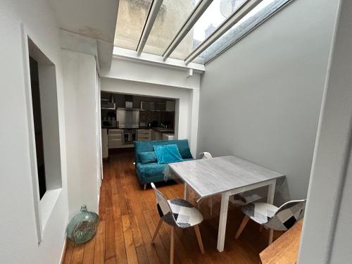 un salon avec une table et un canapé bleu dans l'établissement Home Preize, à Troyes