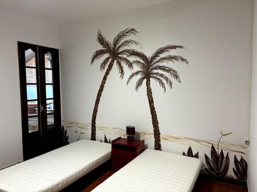 La Maison de Marie, 2 chambres, spacieuse et confortable في سانت لويس: اثنين من أشجار النخيل على الحائط في غرفة