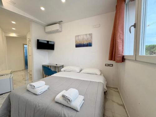 a bedroom with two beds with towels on them at Romano's Luxury Stay b&b Bari in Bari