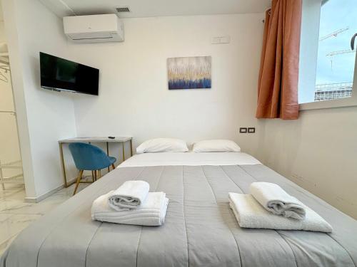 a bedroom with a large bed with towels on it at Romano's Luxury Stay b&b Bari in Bari