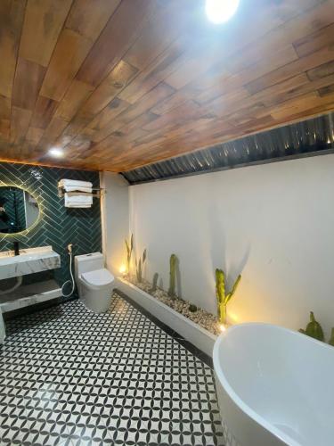 a bathroom with a tub and a toilet and a sink at Sky Garden Moc Chau in Mộc Châu