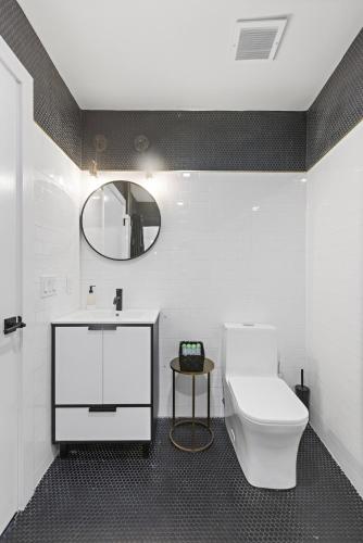a bathroom with a white toilet and a mirror at 1C - Ask About 20Off - Sleeps 5 - Airport 8min - NYC 30min in Newark
