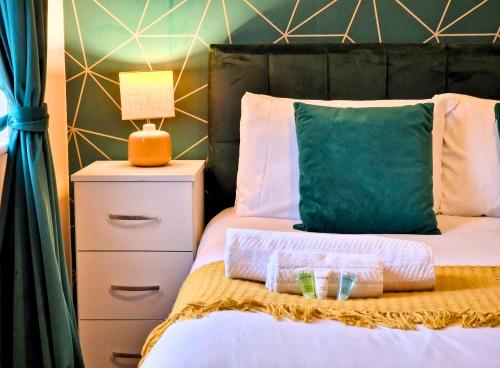 - un lit avec un oreiller vert et 2 paniers dans l'établissement Manchester Townhouse by BEVOLVE - 4 bedrooms - Free Parking, à Manchester