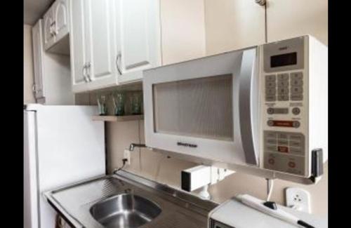 a kitchen with a microwave oven and a sink at Ipanema Beach Apart Hotel in Rio de Janeiro
