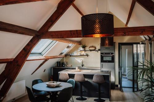 a kitchen with wooden ceilings and a table and chairs at Jacques van Marken Erfgoed in Delft