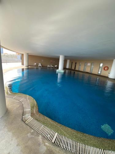 a large swimming pool with blue water in a building at 118 Island Plaza by ZenZone88 in Tanjong Tokong