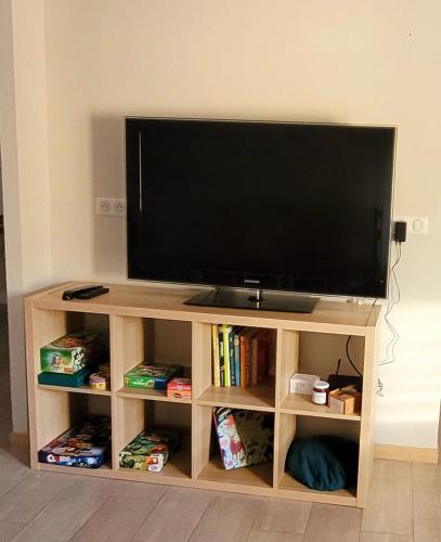un téléviseur à écran plat sur un centre de divertissement en bois dans l'établissement Bel appartement centre ville, à Cabasse