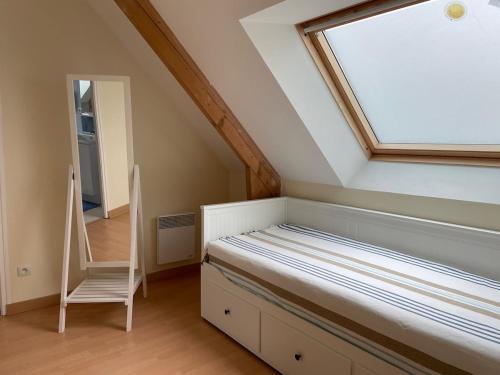 - une chambre avec un lit doté d'une fenêtre et d'une échelle dans l'établissement Gite Les Sardines, à Blainville-sur-Mer