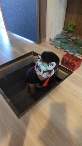 a person in a mask sitting in a room at 風早邸海音 kazahayatei mion in Hōjō