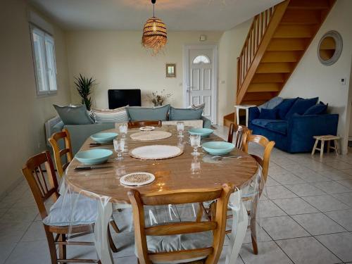 - une table à manger avec des chaises et un canapé dans l'établissement Gite Les Sardines, à Blainville-sur-Mer