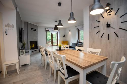 a dining room with a table and a clock on the wall at Hacjenda in Boszkowo-Letnisko