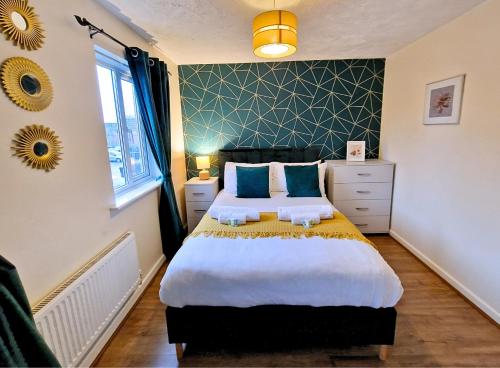 une chambre avec un grand lit avec des oreillers bleus dans l'établissement Manchester Townhouse by BEVOLVE - 4 bedrooms - Free Parking, à Manchester