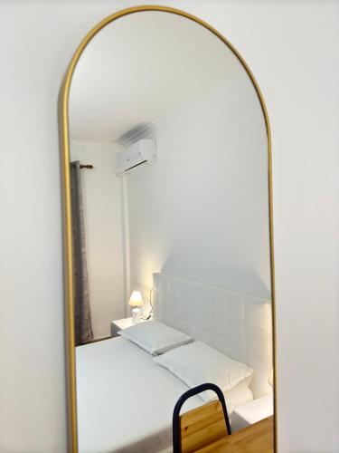 a mirror in a room with a bed and a chair at Hanna Guest House in Përmet