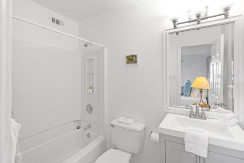 a white bathroom with a tub and a sink and a toilet at 33C Lighthouse Point in Tybee Island