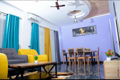 a living room with yellow chairs and a table at Résidence les 3 M in Cotonou