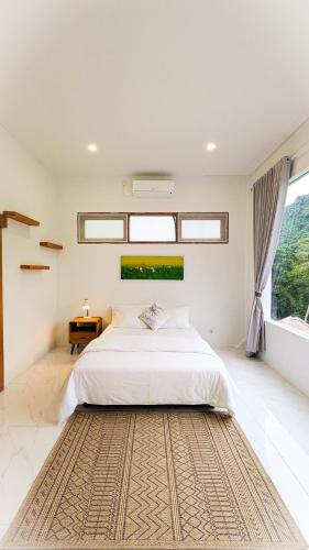 a bedroom with a bed and a large window at The Jungle Villa, Lombok in Mangsit