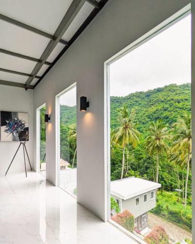 a room with a large window with a view of a mountain at The Jungle Villa, Lombok in Mangsit