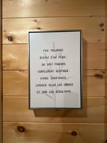 a picture of a sign on a wooden wall at Yomi Chalet in Lac-Superieur