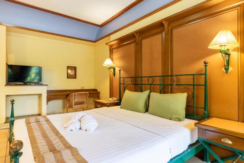 a bedroom with a bed with a towel on it at Pung-Waan Resort & Spa in Kanchanaburi