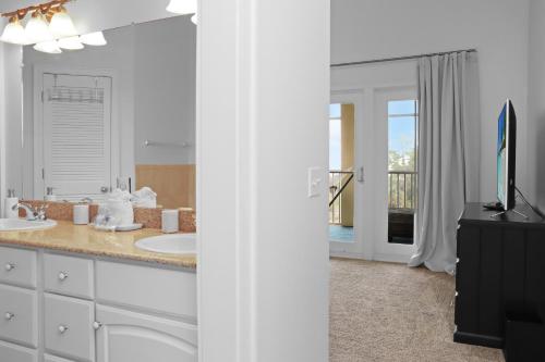 a bathroom with two sinks and a flat screen tv at Catchin Summer by Pristine Properties in Indian Pass