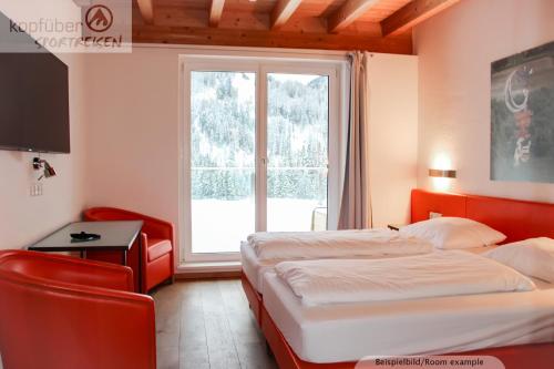 a hotel room with two beds and a window at Sporthotel Shanti in Sankt Anton am Arlberg