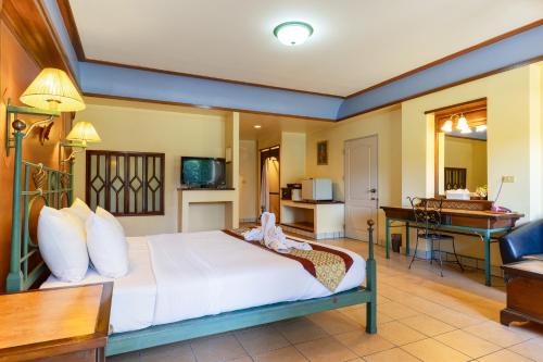 a hotel room with a bed and a desk at Pung-Waan Resort & Spa in Kanchanaburi