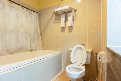 a bathroom with a toilet and a tub and a sink at Pung-Waan Resort & Spa in Kanchanaburi