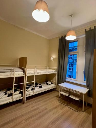 a room with two bunk beds and a table and a window at Fox hostel in Krakow