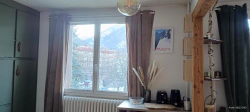 a kitchen with a window with a view of a mountain at Spacious 3 bedrooms apartment in Briançon