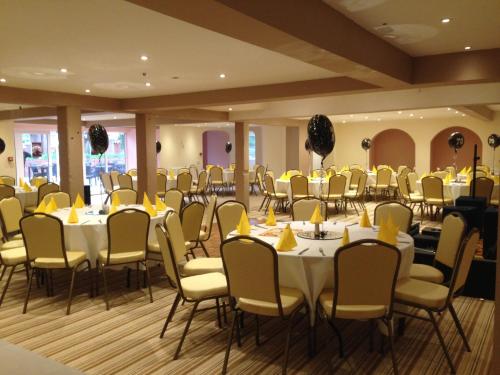 a room filled with tables and chairs with yellow napkins at The Royal Hotel in Mundesley