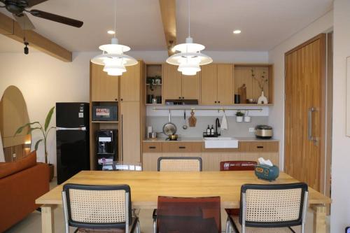 a kitchen with a wooden table and chairs at Twelve Stones Dago Village in Bandung