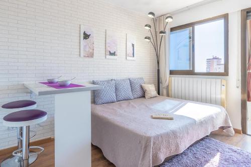 a bedroom with a bed and a table with a stool at Apartamento Niza in Oropesa del Mar