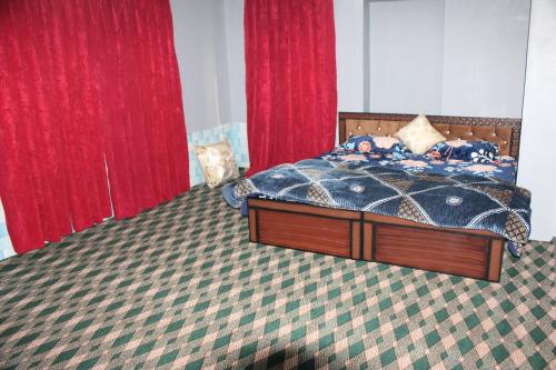 a bedroom with a bed and red drapes at Khadim Villa & Travel Planners in Srinagar