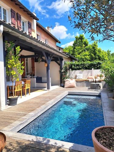 une cour arrière avec une piscine et une maison dans l'établissement Charming house with pool, near metro, à Lyon